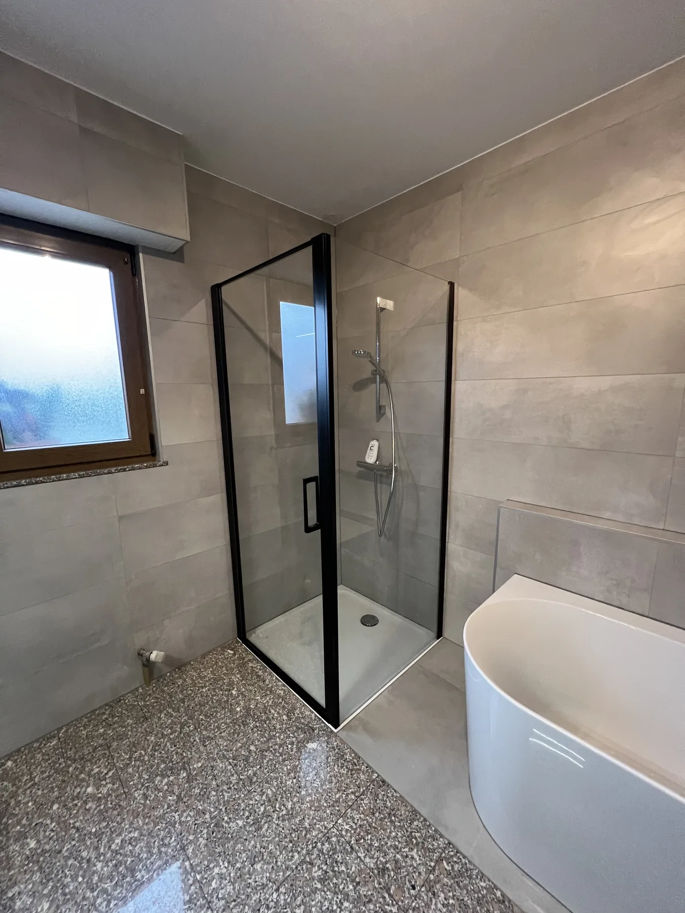 Cabine de douche avec profilés noirs sur grès grand format