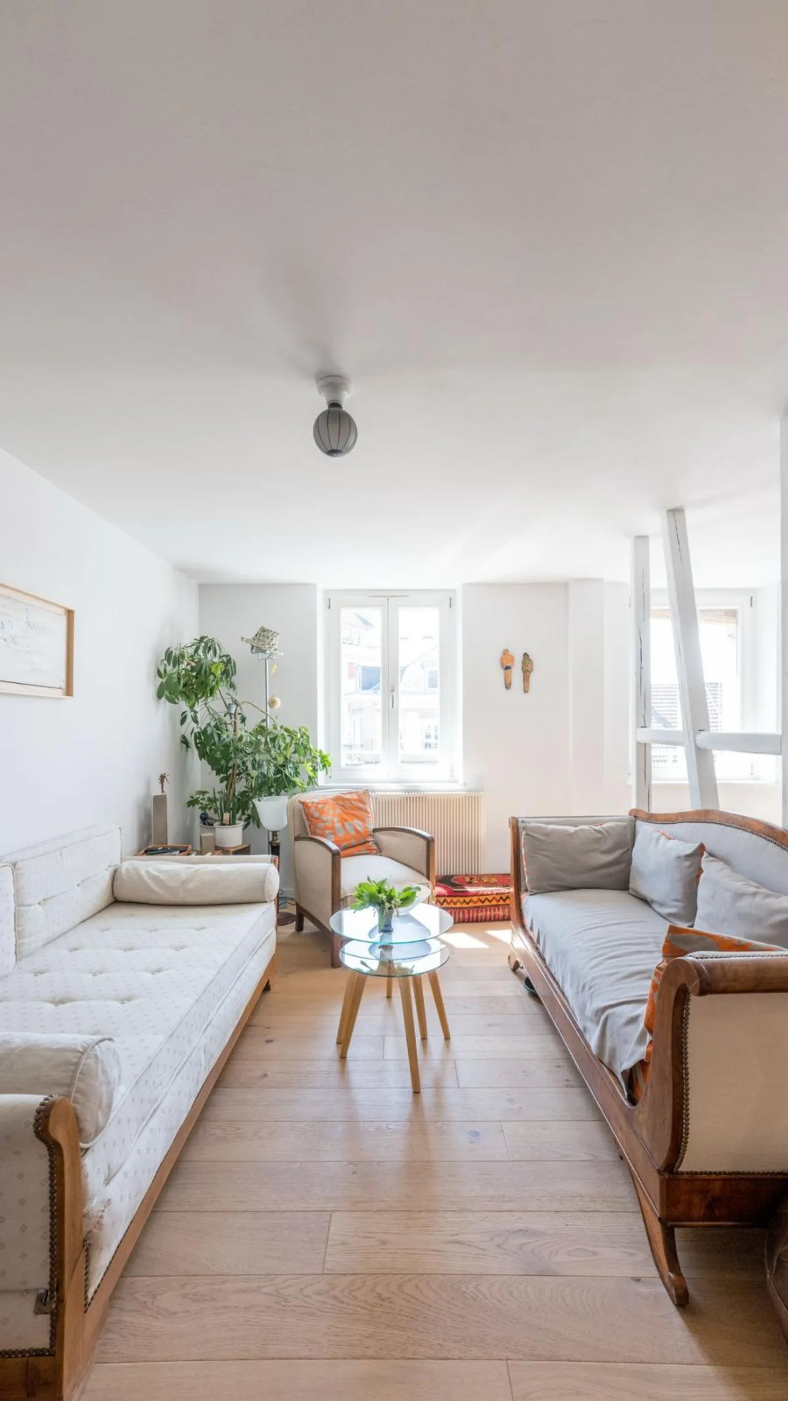 Séjour avec banquettes anciennes, parquet chêne et plafond blanc